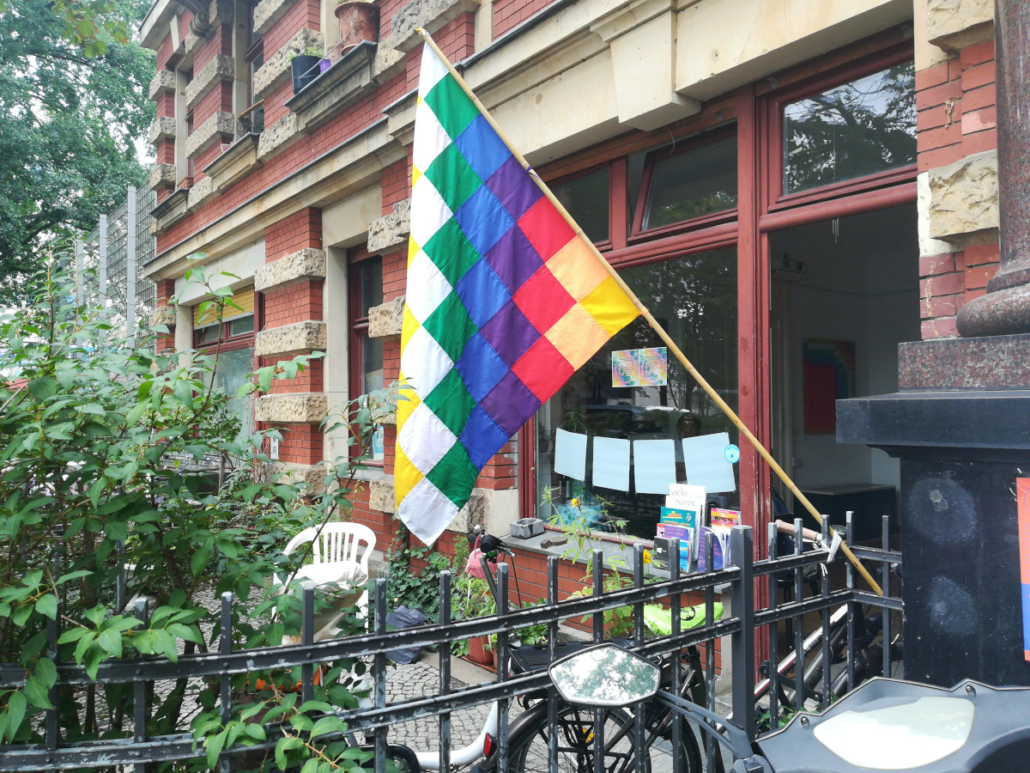 Der B-Laden mit Wiphala-Fahne als Werbung für die Ortstermin Ausstellung von Enrique Antezana, 2022